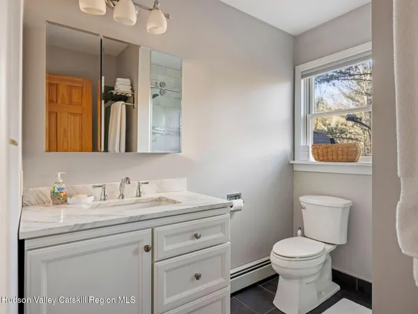 a bathroom with a window a toilet and a shower