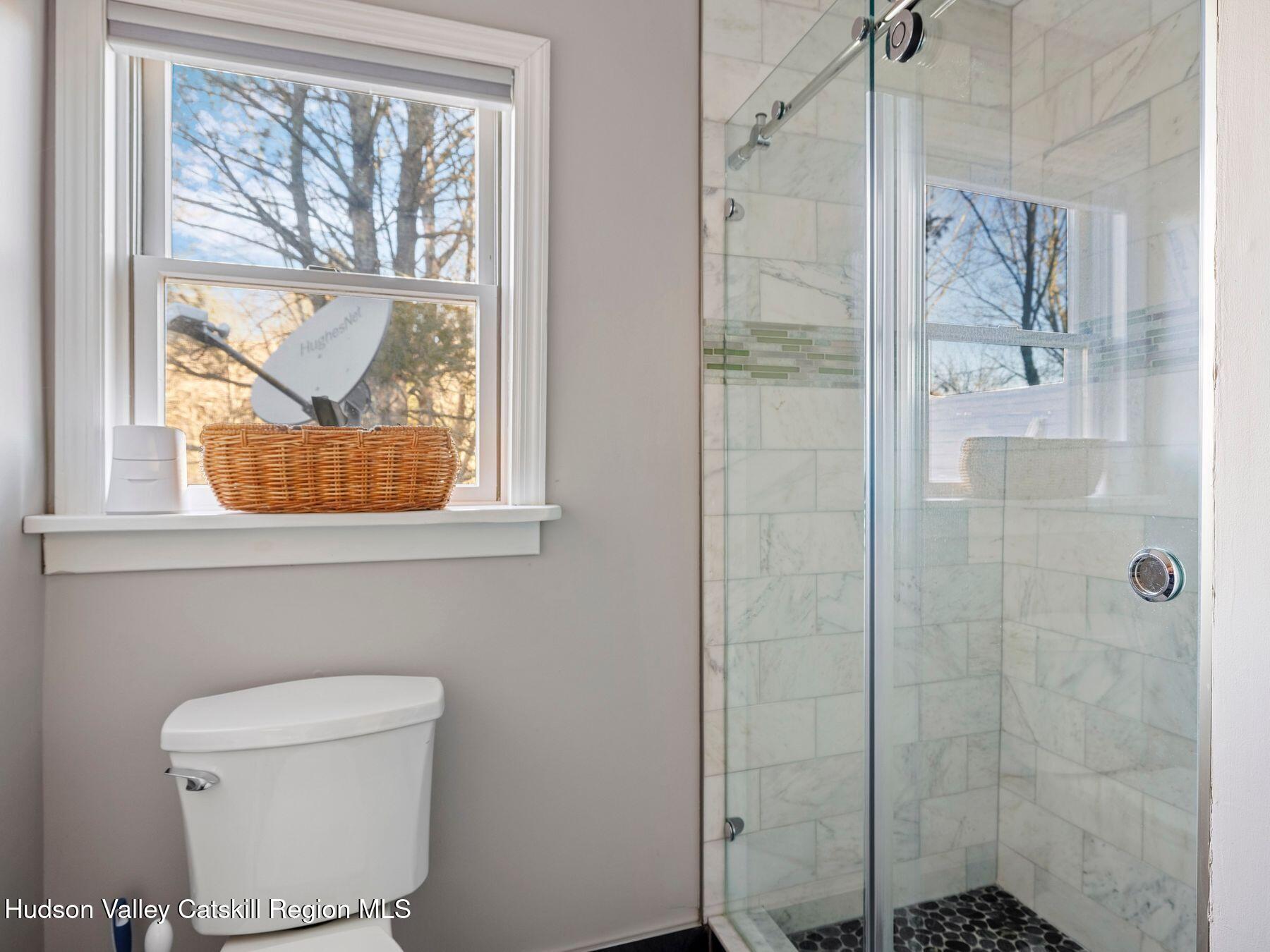 83 Lawrence Road Jewett, NY 12442 - Photo 29 of 52 a bathroom with a window a toilet and a shower