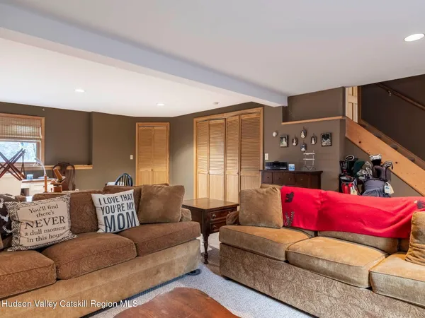 a living room with furniture a flat screen tv and a rug