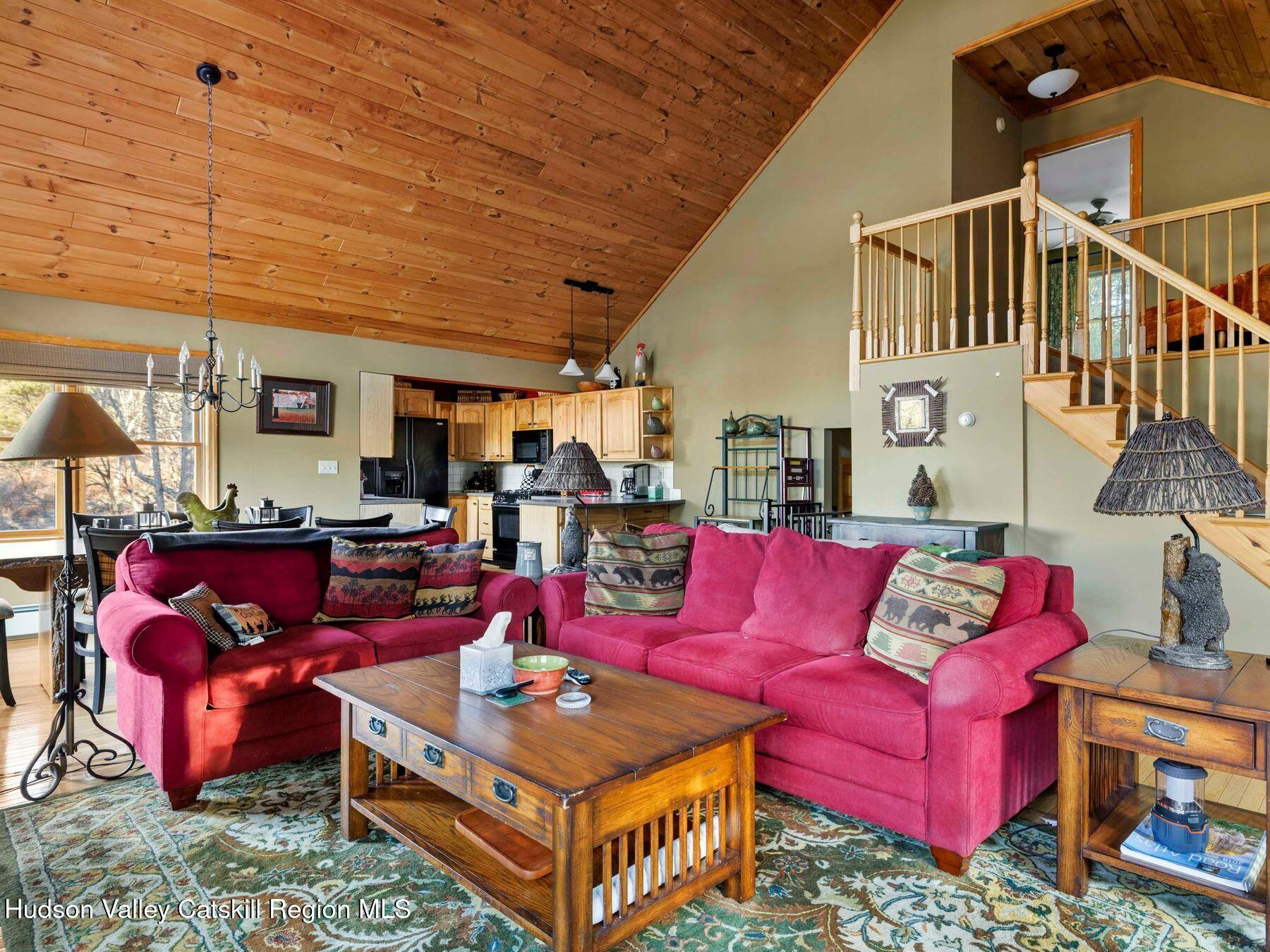 83 Lawrence Road Jewett, NY 12442 - Photo 5 of 52 a living room with furniture a red rug and a chandelier