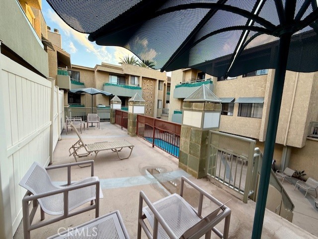 19009 Sherman Way, Unit 34 Reseda, CA 91335 - Photo 18 of 27 a view of a patio with table and chairs with wooden floor and fence