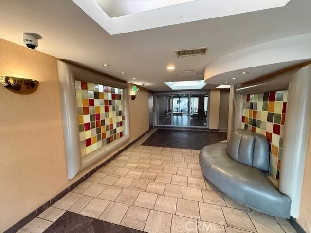 a view of a hallway with wooden floor and a bathroom