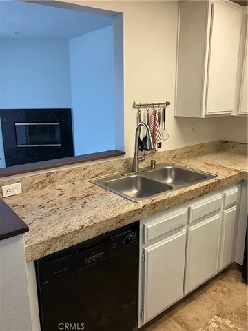 a kitchen with granite countertop a sink and a stove