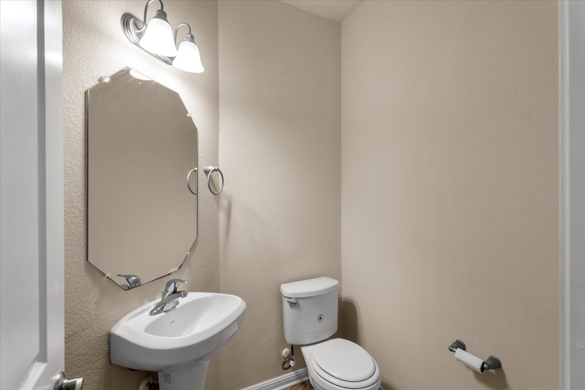 3451 Mayfield Ranch Boulevard, Unit 311 Round Rock, TX 78681 - Photo 16 of 40 Pedestal sink with chrome faucet, octagonal mirror, and a two-light vanity fixture