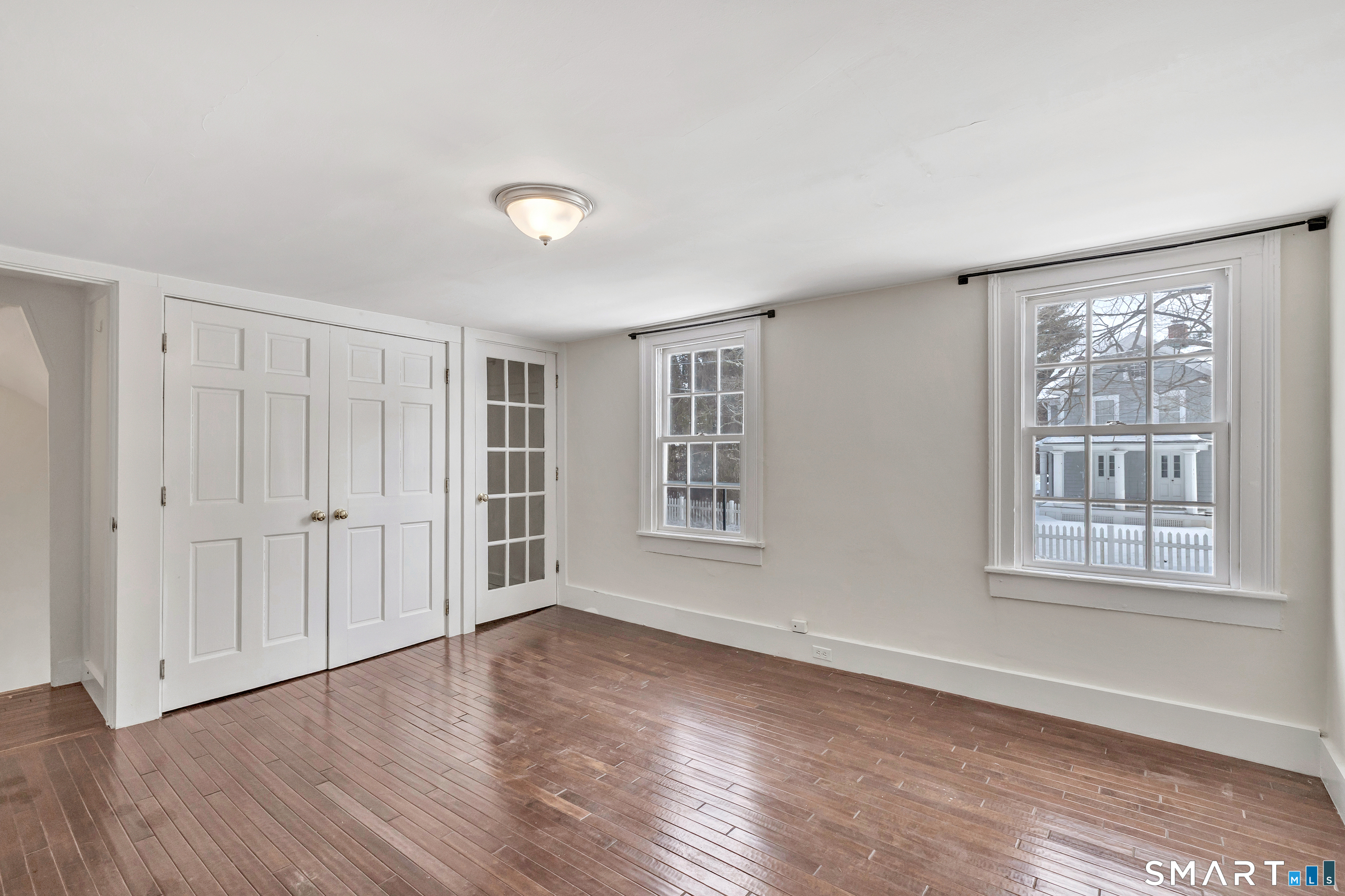 274 Lyons Plain Road Weston, CT 06883 - Photo 14 of 40 an empty room with wooden floor and windows