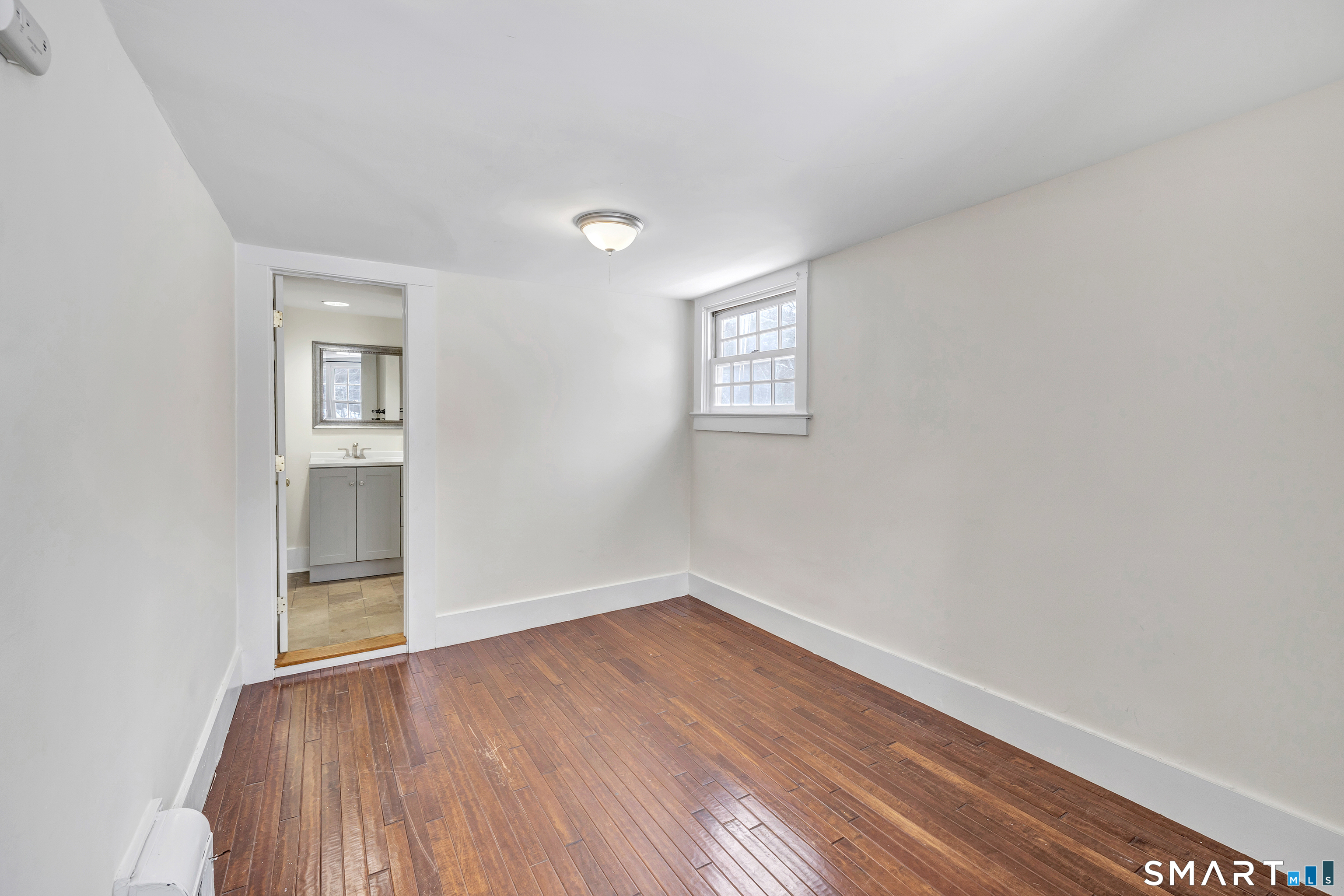 274 Lyons Plain Road Weston, CT 06883 - Photo 16 of 40 an empty room with wooden floor and windows