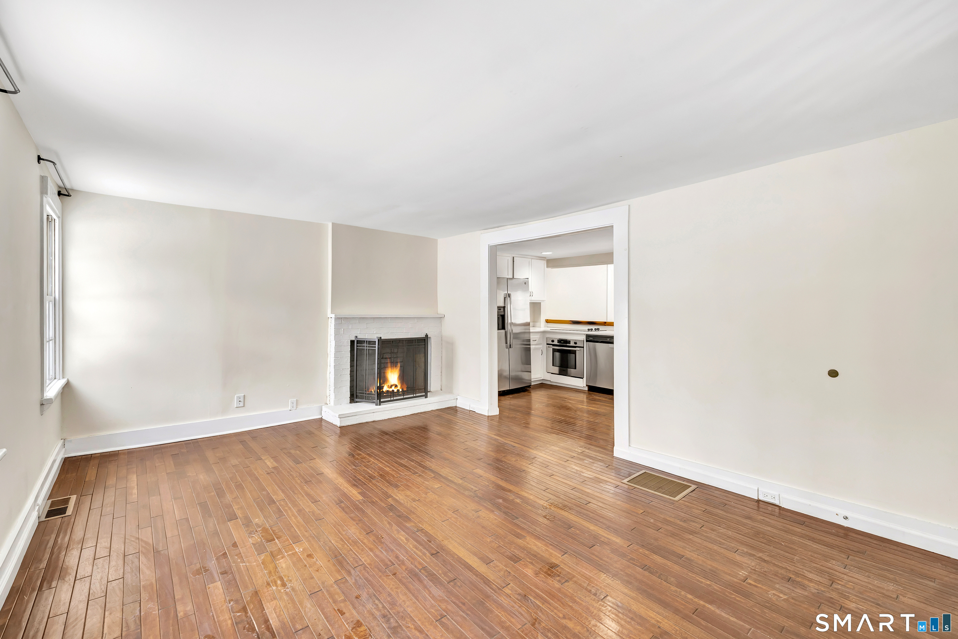 274 Lyons Plain Road Weston, CT 06883 - Photo 5 of 40 a view of empty room with wooden floor and fireplace