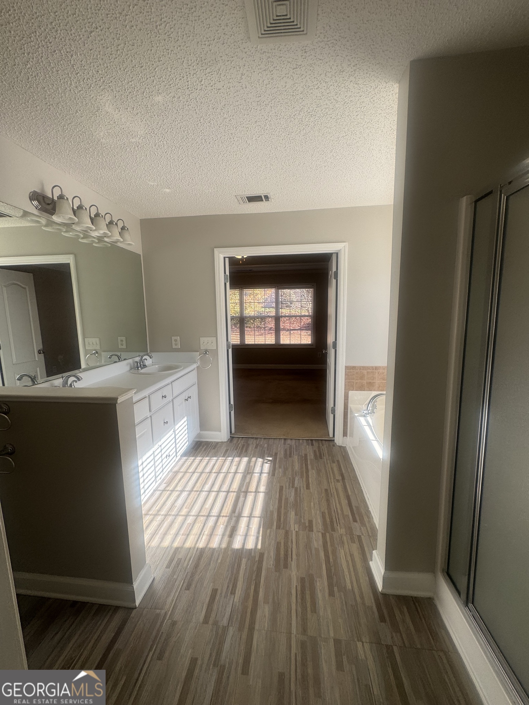 180 Laurel Oaks Lane Jefferson, GA 30549 - Photo 22 of 26 a view of a kitchen from the hallway with wooden floor