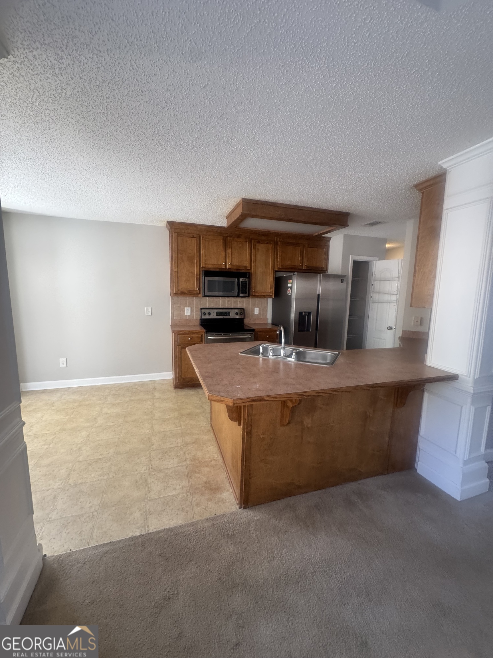 180 Laurel Oaks Lane Jefferson, GA 30549 - Photo 9 of 26 a kitchen with kitchen island a sink a stove top oven a counter space and cabinets