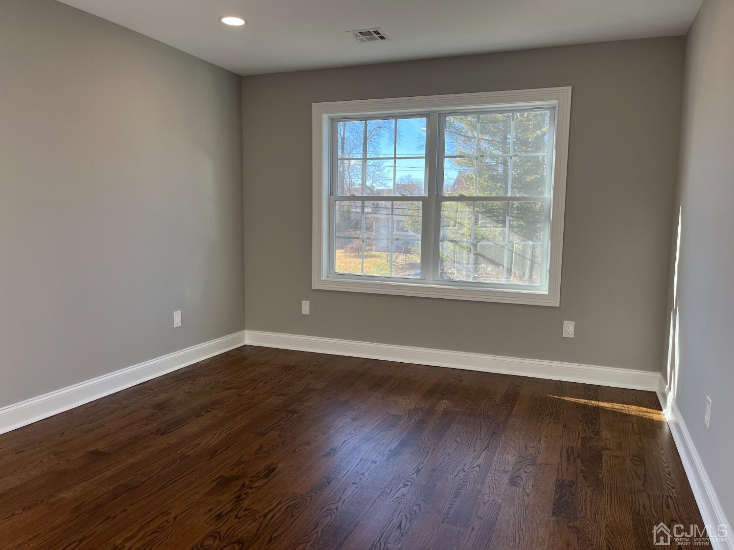 80 Kimberly Road Colonia, NJ 07067 - Photo 22 of 33 an empty room with wooden floor and windows