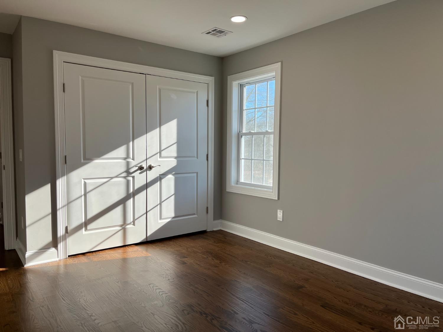 80 Kimberly Road Colonia, NJ 07067 - Photo 23 of 33 a view of an empty room with wooden floor and a window