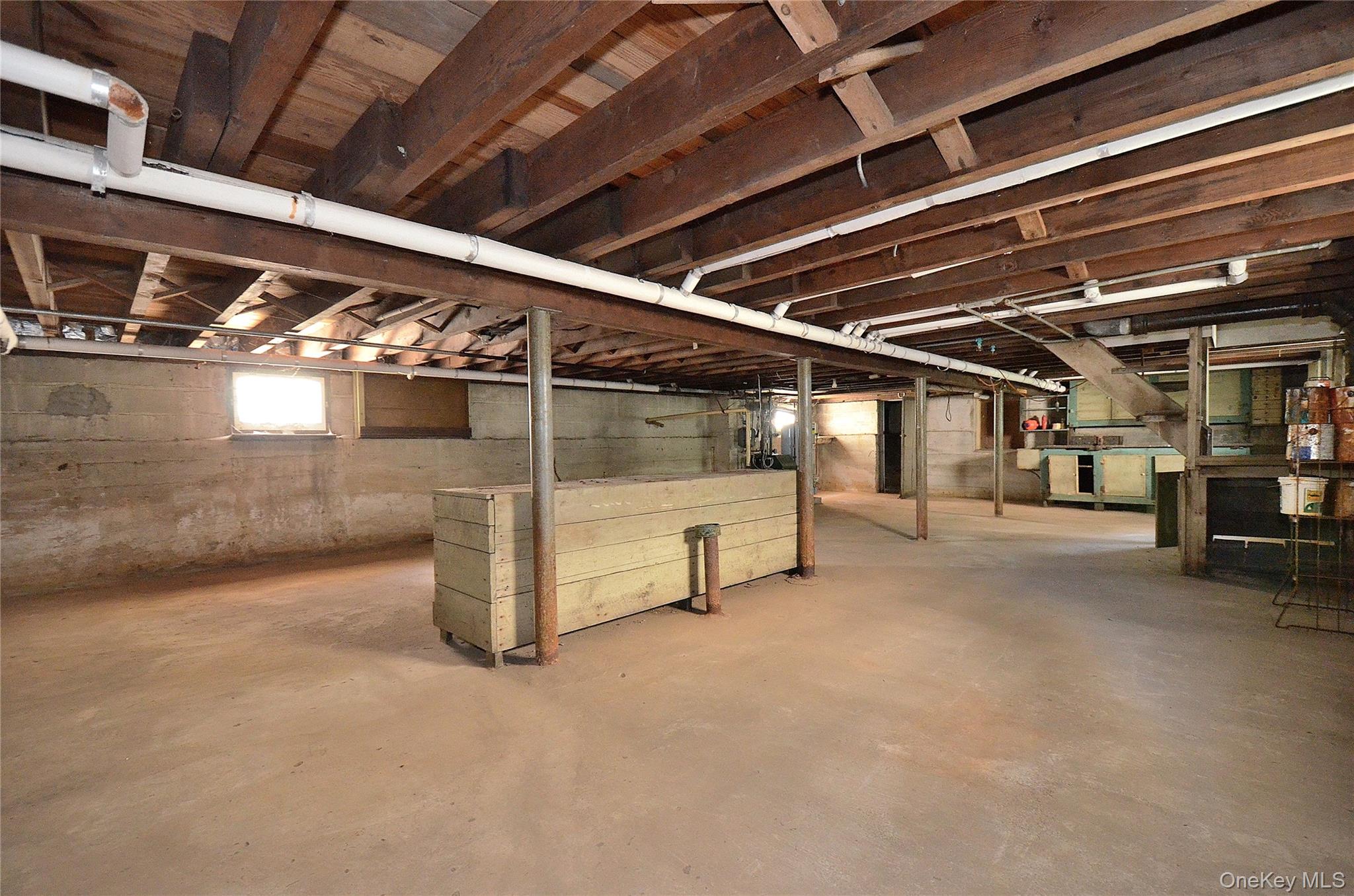 2586 Riverside Drive Wantagh, NY 11793 - Photo 22 of 28 Expansive unfinished basement featuring exposed wood ceiling joists and concrete flooring