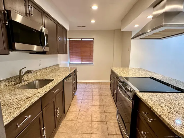 a kitchen with granite countertop a sink and a stove