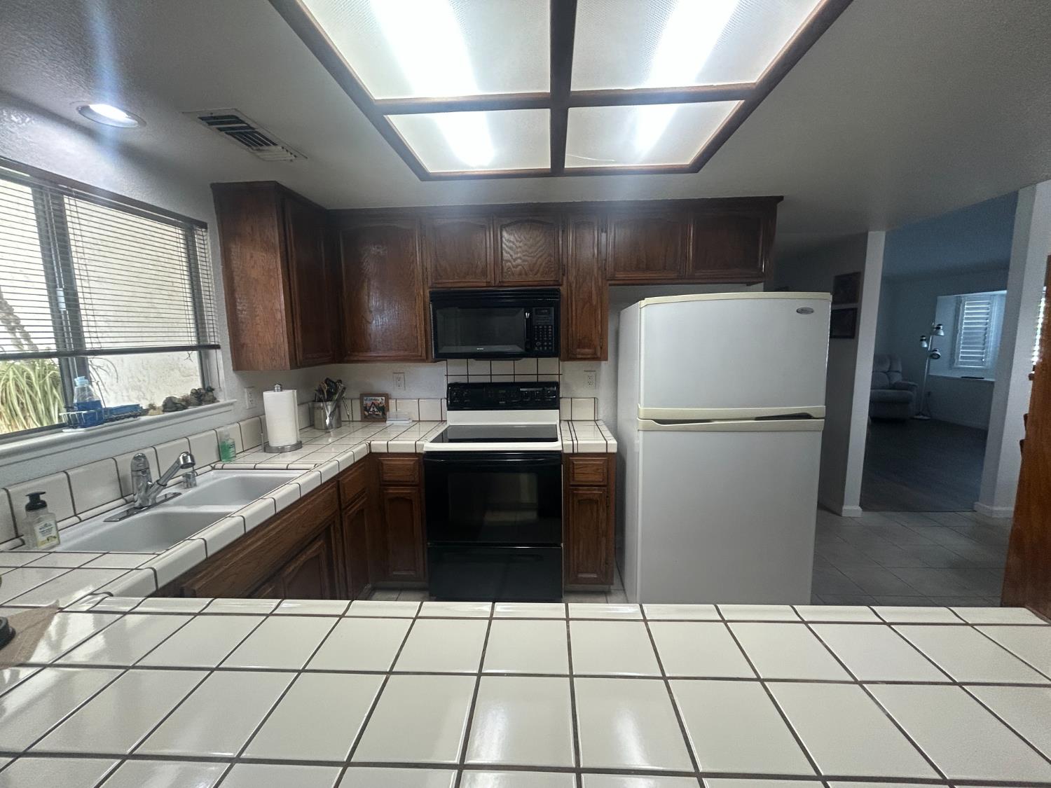 4529 Fallbrook Place Salida, CA 95368 - Photo 11 of 26 a kitchen with a sink a refrigerator and a stove top oven