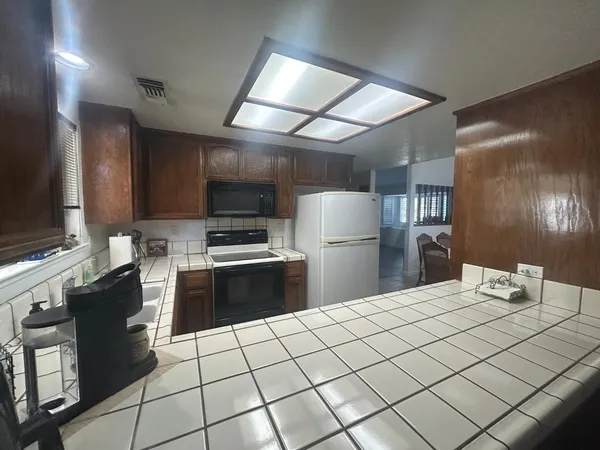 a kitchen with granite countertop a refrigerator and a stove top oven