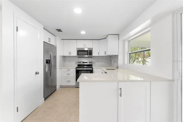 a kitchen with stainless steel appliances a refrigerator sink and stove