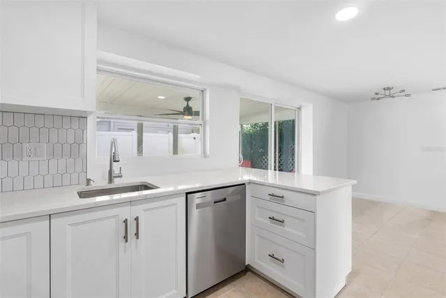 a kitchen with white cabinets and sink