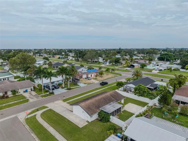 an aerial view of a city with lots of residential buildings and mountain view in back