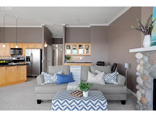 a living room with furniture kitchen view and a window