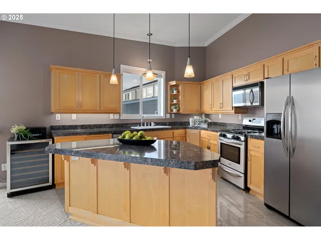 a kitchen with stainless steel appliances granite countertop a sink a stove and refrigerator