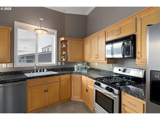 a kitchen with stainless steel appliances a sink stove and microwave