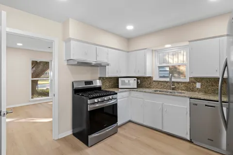 a kitchen with granite countertop a stove sink and cabinets