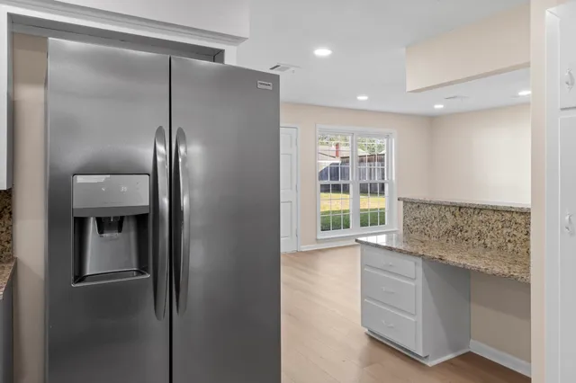 a kitchen with stainless steel appliances granite countertop a refrigerator and a sink
