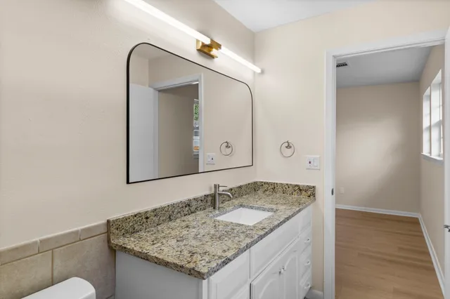 a bathroom with a granite countertop sink and a mirror