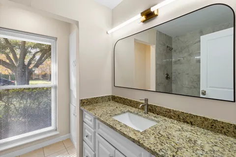 a bathroom with a granite countertop sink and a mirror