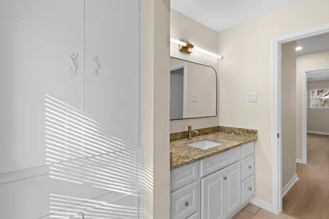 a bathroom with a granite countertop sink and a mirror