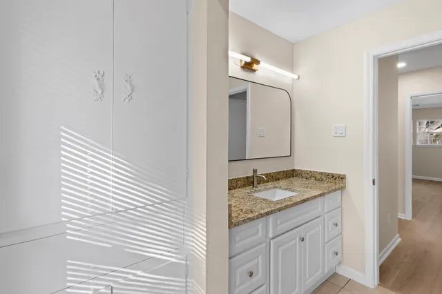 a bathroom with a granite countertop sink and a mirror