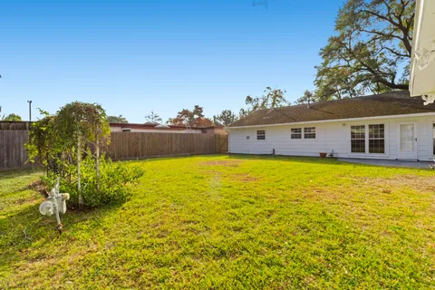 a swimming pool with an outdoor seating and house in the background