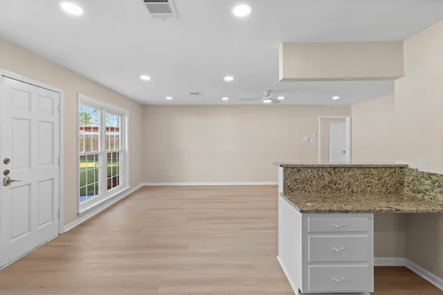 a view of kitchen with granite countertop cabinets and window