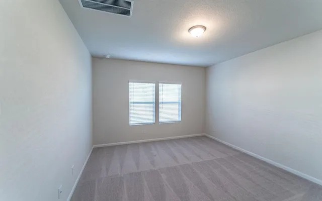 an empty room with a window and a mirror