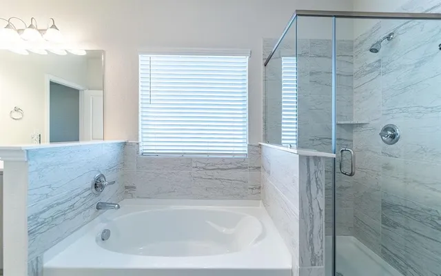 a white bath tub sitting next to a white sink and vanity