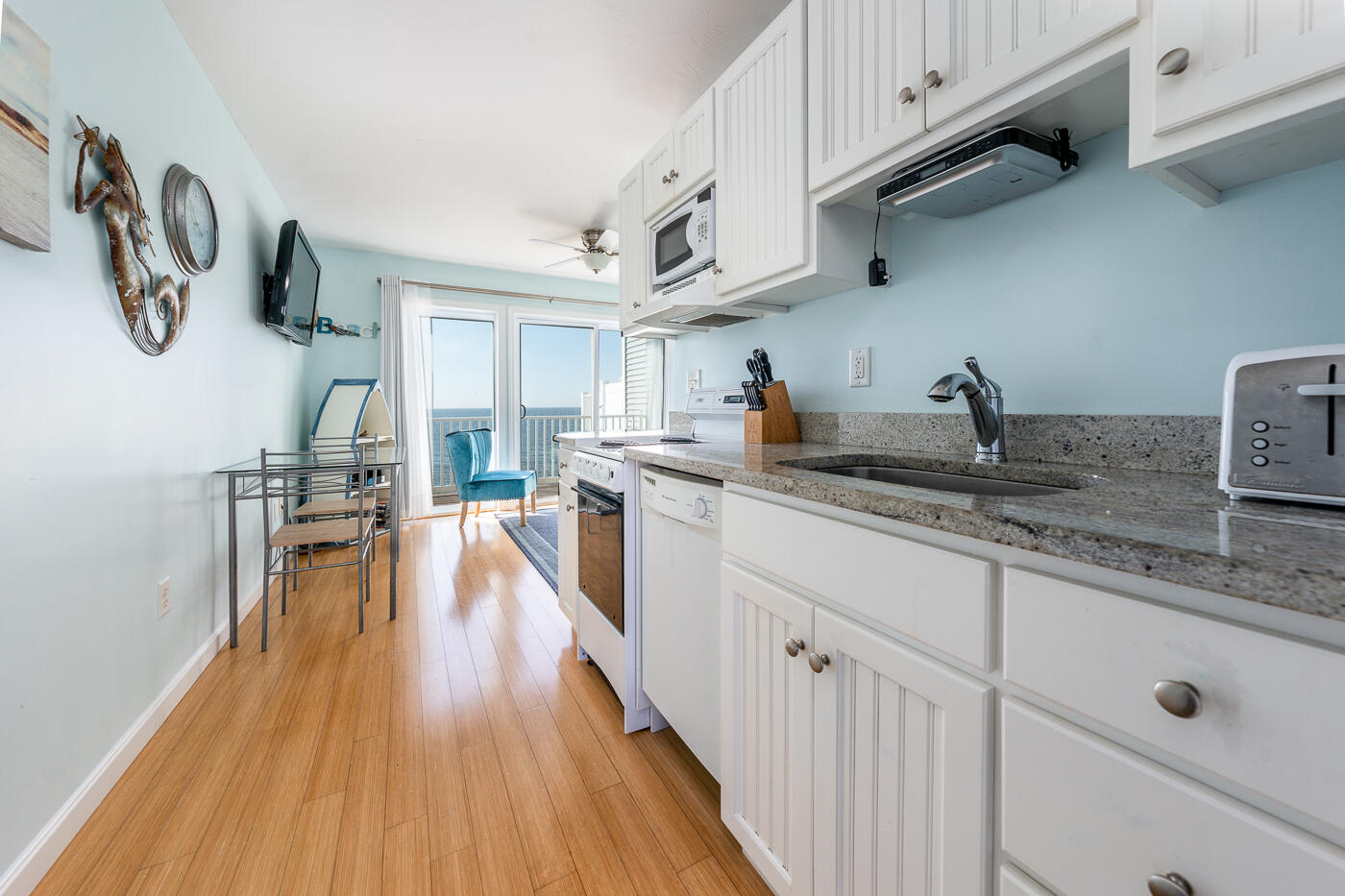 482 Shore Road, Unit 19 Truro, MA 02666 - Photo 9 of 17 a kitchen with stainless steel appliances granite countertop a lot of counter space and wooden floors