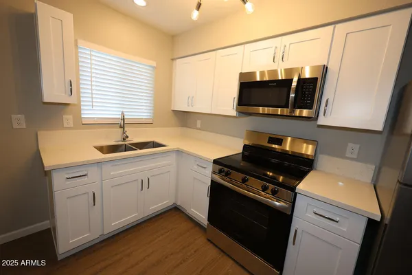 a kitchen with stainless steel appliances a stove microwave and a sink