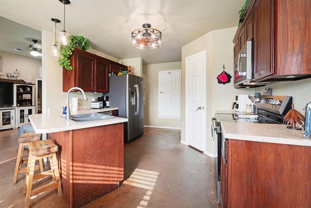 1890 County Road Sumner, TX 75486 - Photo 12 of 20 a kitchen with granite countertop a sink cabinets and appliances