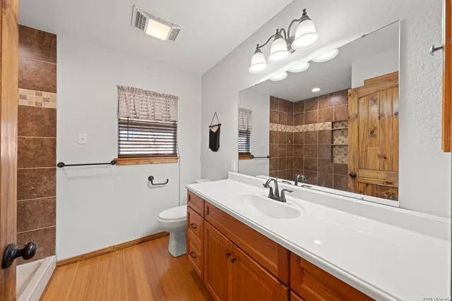 a bathroom with a sink a toilet and a mirror