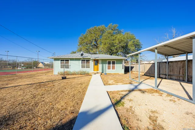 a view of a house with backyard and sitting area