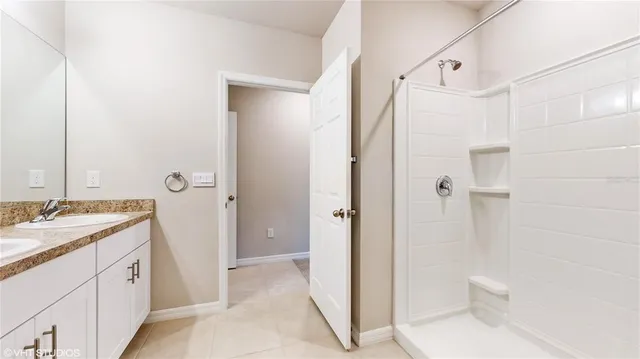 a bathroom with a granite countertop shower a sink and a mirror