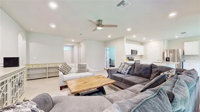 a living room with furniture kitchen view and a flat screen tv