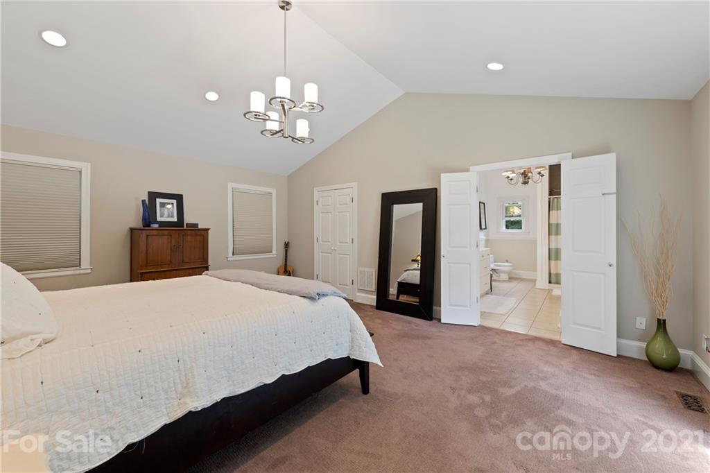 4223 Chelmsford Road Charlotte, NC 28211 - Photo 18 of 33 a bedroom with a large bed and a chandelier