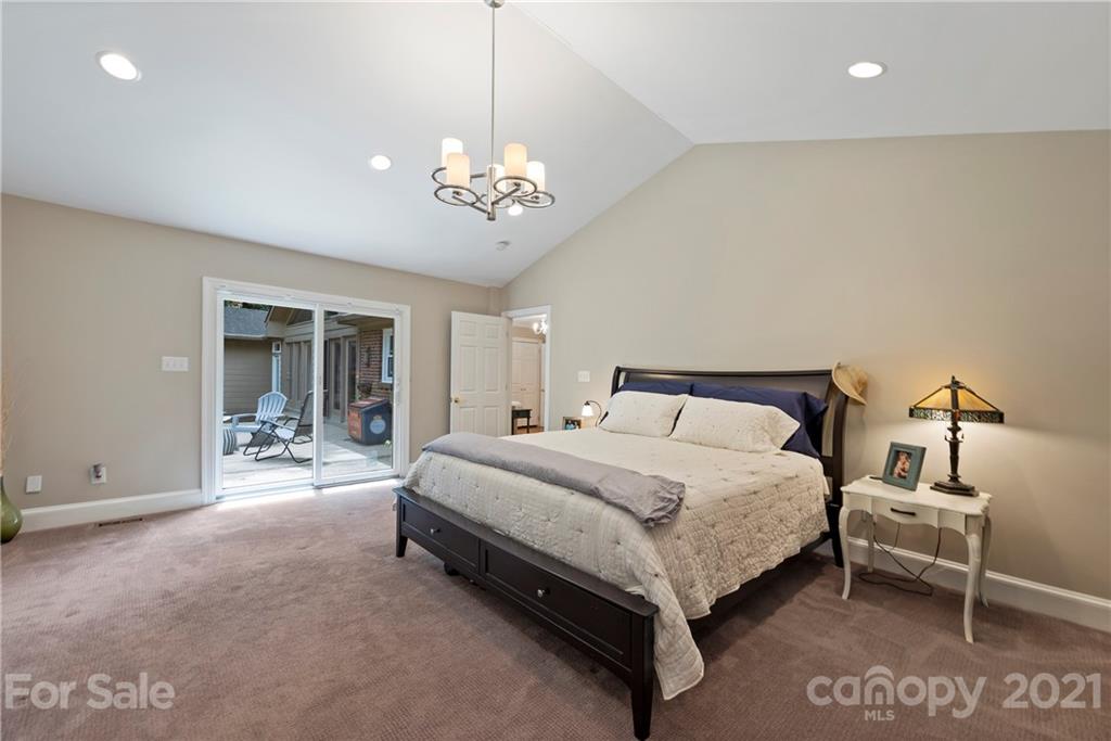 4223 Chelmsford Road Charlotte, NC 28211 - Photo 19 of 33 a spacious bedroom with a bed and a chandelier