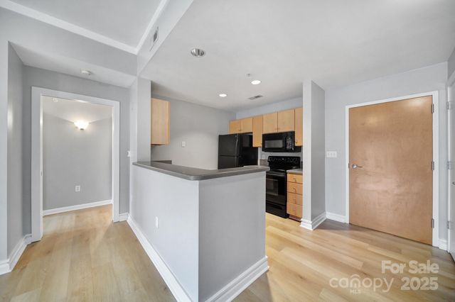 a view of kitchen with stainless steel appliances kitchen island refrigerator stove and cabinets