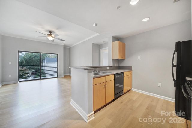 a kitchen with stainless steel appliances granite countertop a stove a refrigerator and a granite counter tops with white cabinets