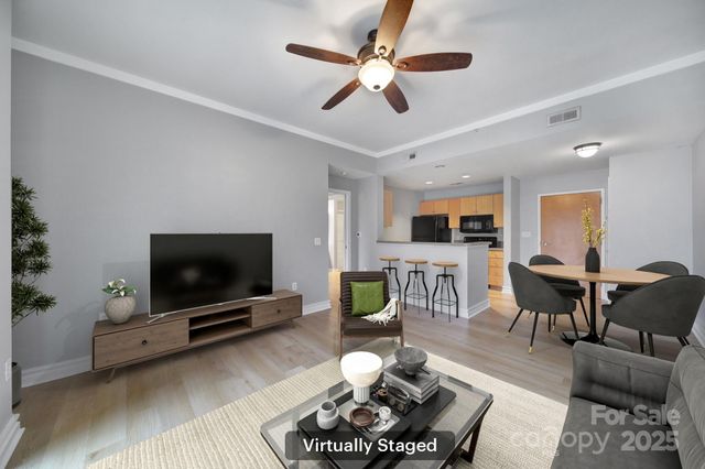 a living room with furniture a flat screen tv and a chandelier