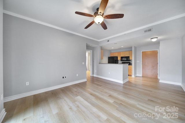a view of empty room with wooden floor and ceiling fan
