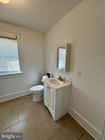 a bathroom with a sink a toilet and mirror