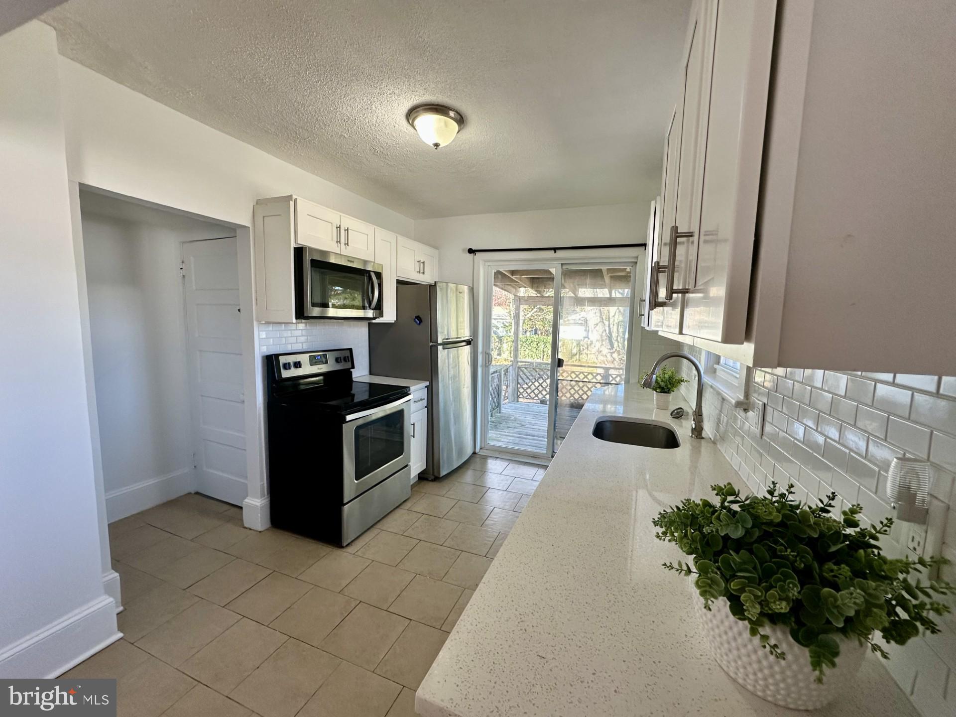 139 Otis Avenue Tuckerton, NJ 08087 - Photo 7 of 27 a large white kitchen with a stove a microwave and a refrigerator